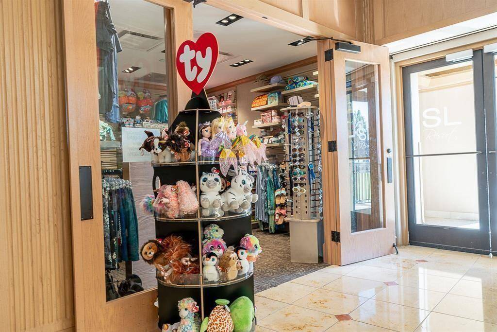 Essentials retail store entrance featuring a range of plush toys displayed on a circular stand, including many shopping essentials.