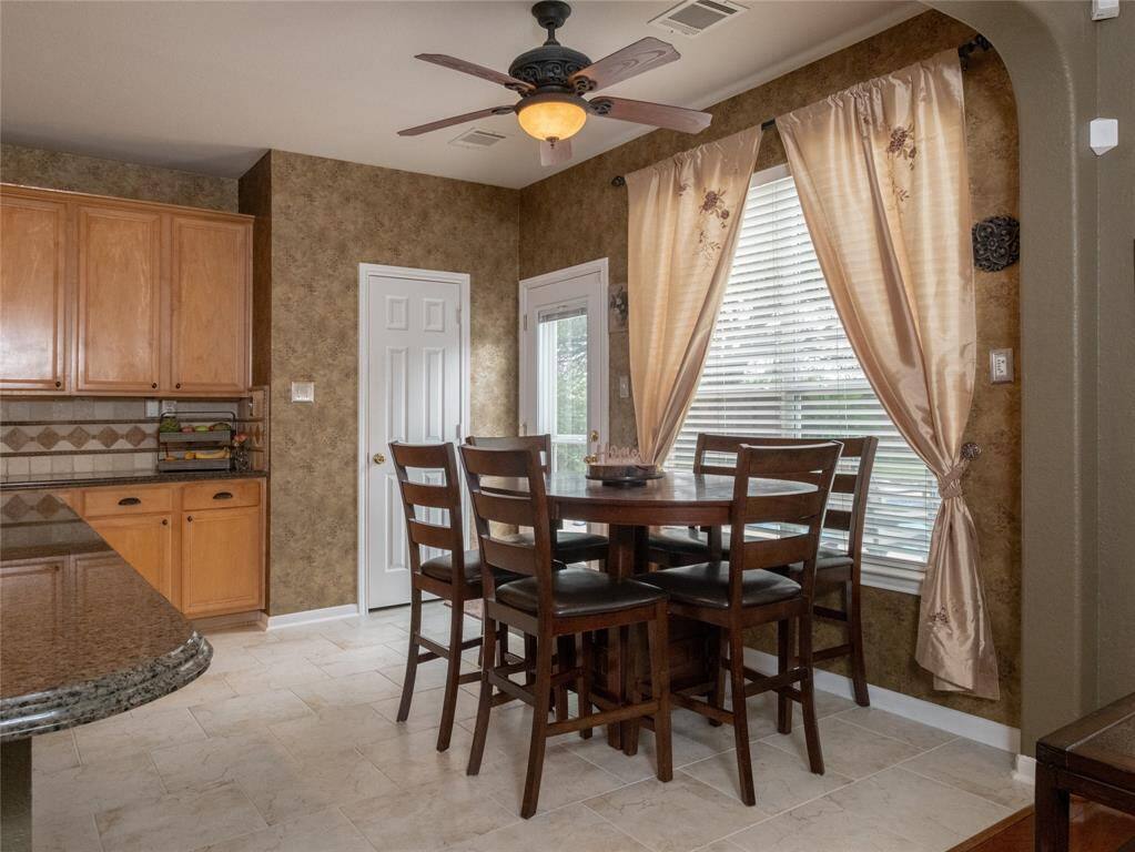 This cozy dining area is accented by warm wood cabinets, tile flooring, creating a space for family to enjoy meals together.