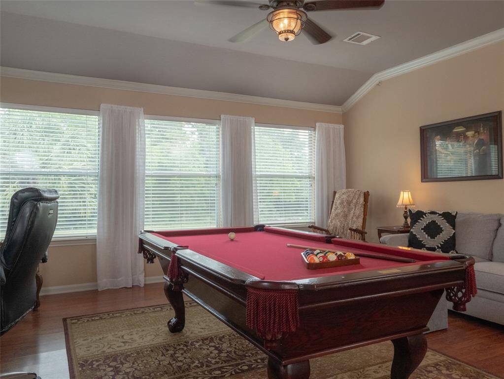 Welcome to this fun game room at the top of the stairs! Check out the pool table, large windows with ample natural light, and a cozy seating area, creating a perfect space for relaxation and entertainment. The pool table and pool table accessories will stay with the home.