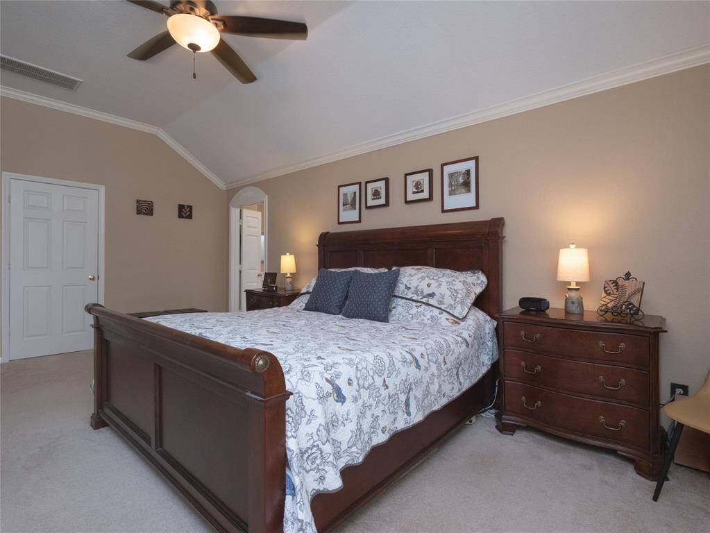 You will love this large primary bedroom featuring a classic design with vaulted ceiling, neutral walls, offering a cozy and elegant atmosphere. You will want to check out the Texas size walk in closet through the open door!