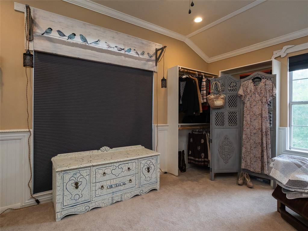 WOW! This TEXAS sized walk in closet offers so much space for all your clothing and shoe storage needs! The warm beige walls and crown molding, plus the wainscoting on the walls create a relaxing space.