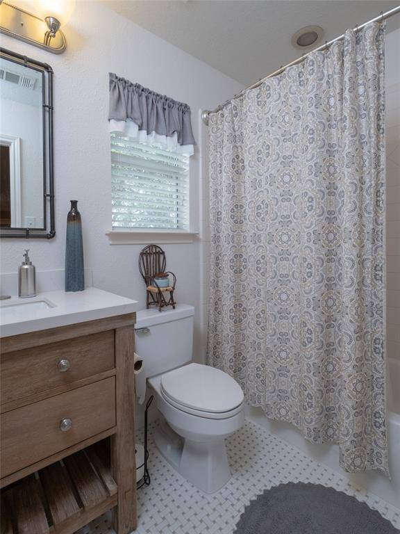 Enjoy this main bathroom featuring an updated wood vanity, new mirror to compliment the design and a soft light fixture. The window adds natural light, complementing the neutral tones and tile flooring.