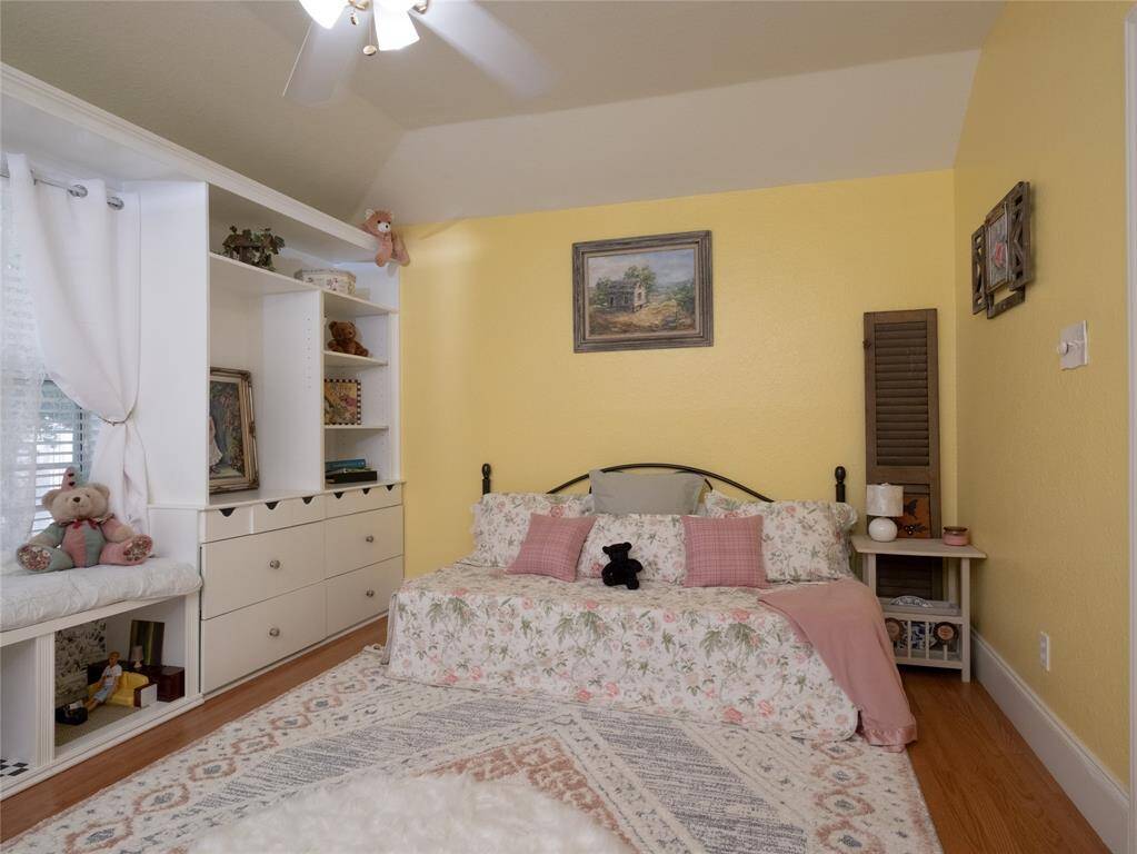 Don't miss this spacious bedroom with soft yellow walls. Ample storage is provided by built-in shelves and drawers.