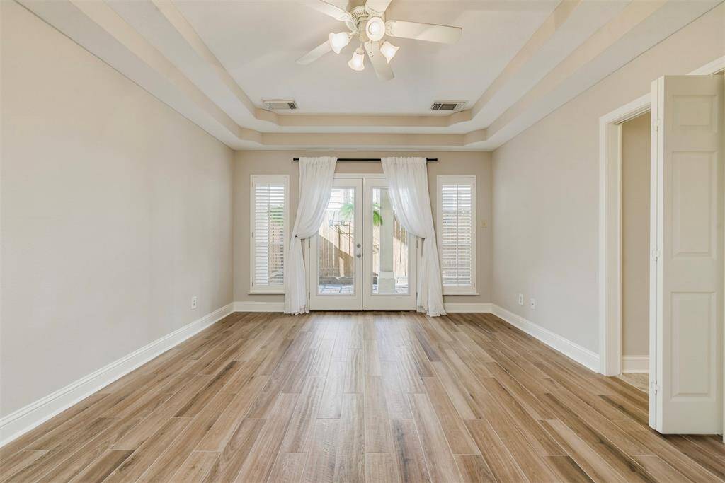 The Master Bedroom with Recent Wood Tile Floors and Neutral Interior Paint