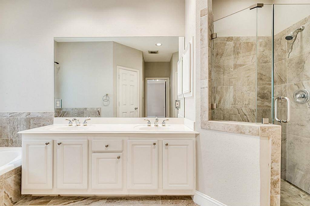 The upgraded Master Bathroom with Tile floors & shower w/seat, Seamless Shower Surround, and paint