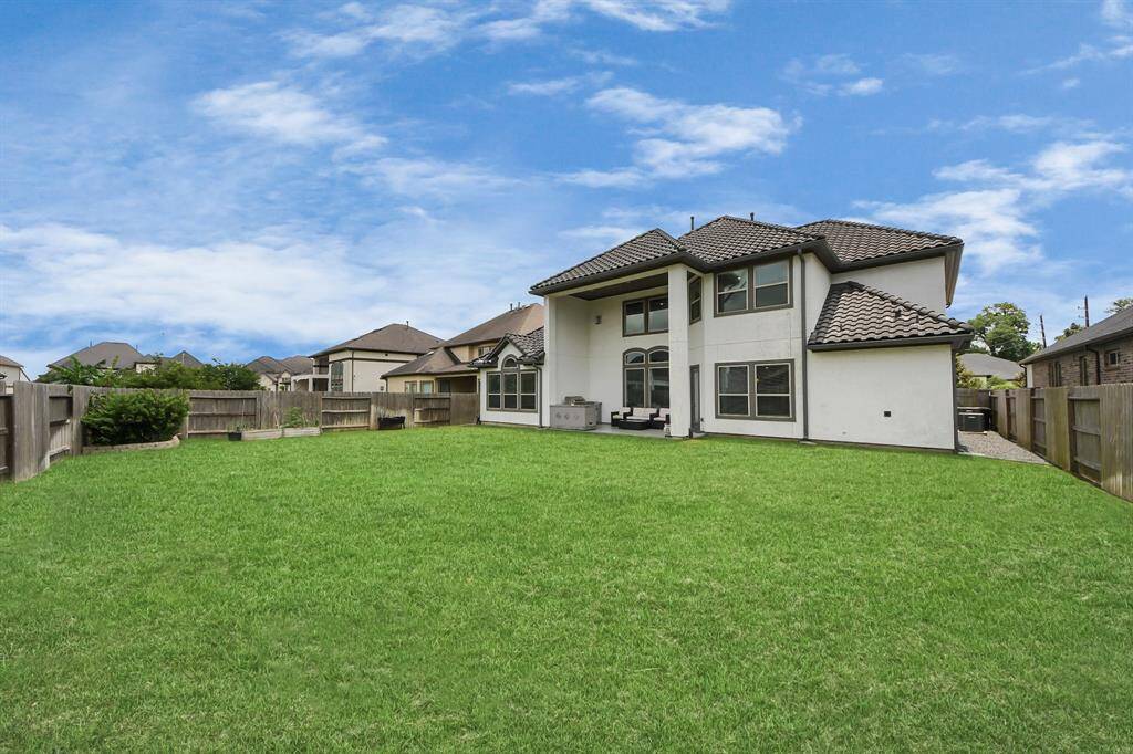 Large backyard with a spacious, covered patio and outdoor kitchen