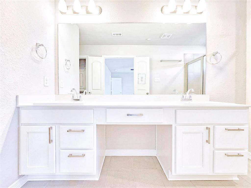 The primary bath offers dual sinks, a vanity, and plenty of storage