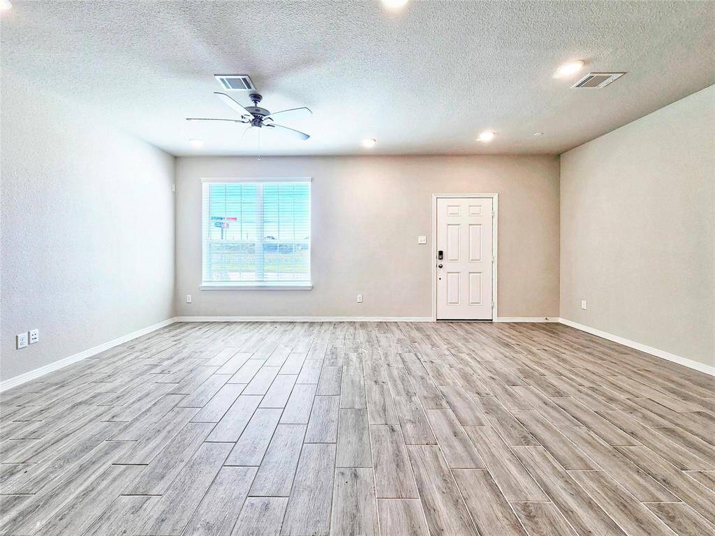 This living/dining combo area is bathed in natural light from this large window at the front of the home
