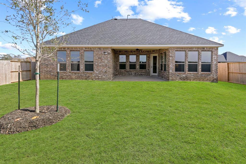 The covered patio offers a peaceful space to unwind and take in the beauty of the expansive backyard—perfect for morning coffee, evening gatherings, or simply enjoying the outdoors in comfort.