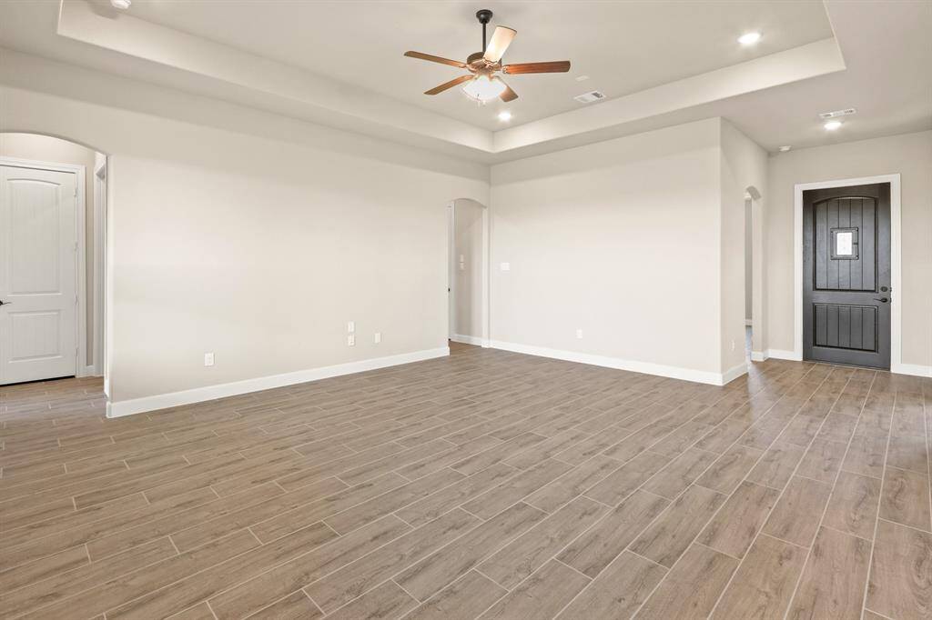 Stepping through the front door, you're welcomed by elegant, easy-care tile flooring and a spacious open-concept living area accented by stunning coffered ceilings—setting the tone for comfort and style throughout the home.