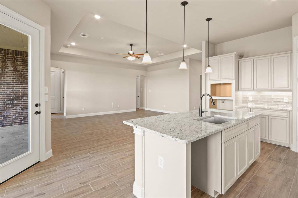 Designer pendants spotlight expansive island. Culinary dreams meet stylish reality.