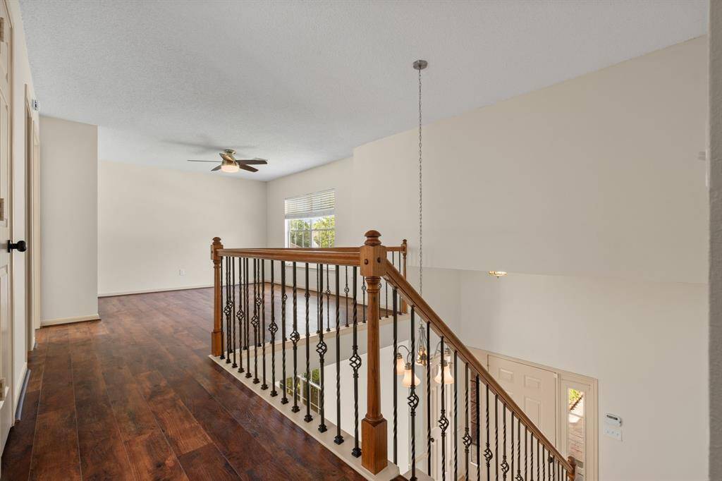 Bathed in abundant natural light, this expansive second-floor game room or flex space provides endless opportunities for entertainment or relaxation, all while overlooking the grand entry below.