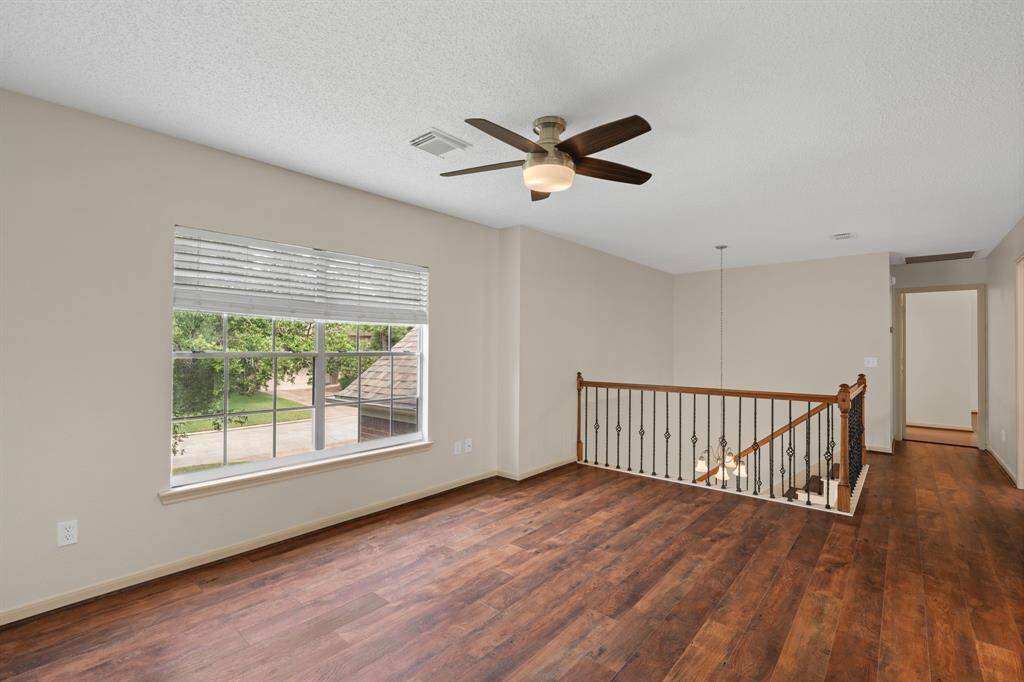 Bathed in abundant natural light, this expansive second-floor game room or flex space provides endless opportunities for entertainment or relaxation, all while overlooking the grand entry below.