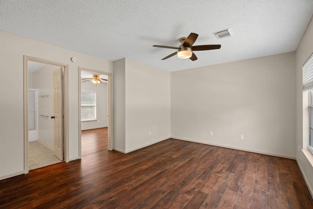 Natural light floods this spacious third bedroom, featuring a large window with serene backyard views. Its seamless connection to the adjacent game room creates an even more expansive and open feel.