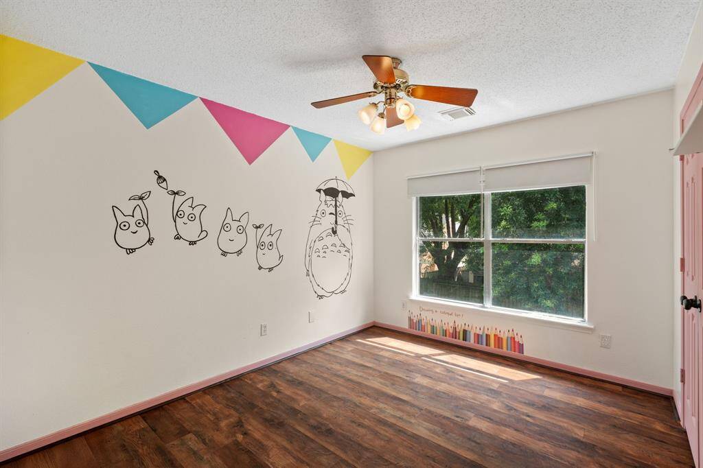 Unleash imagination in this fun and spacious secondary bedroom, beautifully painted by a local artist! Featuring built-in bookshelves, soft flooring for comfort, and an organized closet, it's a dream space for any child.