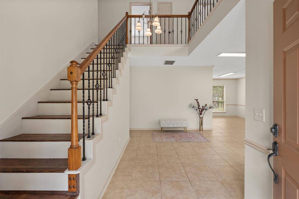 Welcoming entryway with beautiful stairs.
