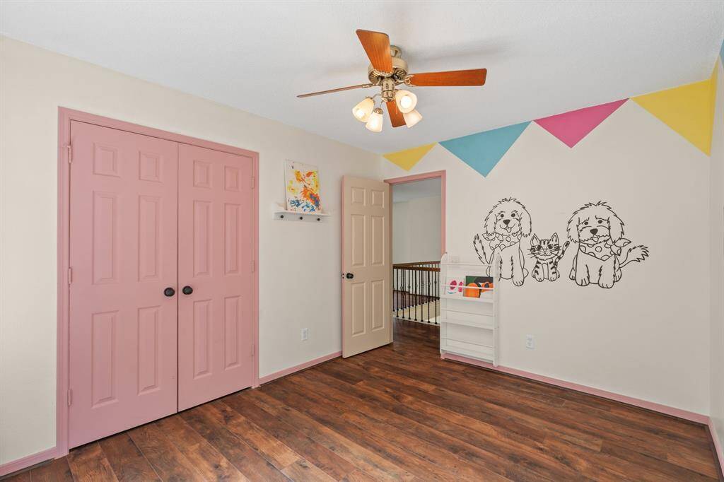 Unleash imagination in this fun and spacious secondary bedroom, beautifully painted by a local artist! Featuring built-in bookshelves, soft flooring for comfort, and an organized closet, it's a dream space for any child.