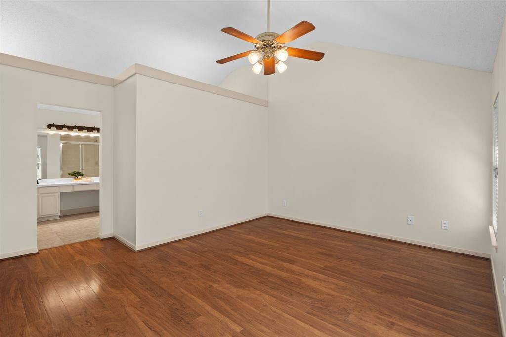 Retreat to this spacious and light-filled primary bedroom, boasting a high ceiling that enhances its airy feel. An elegant archway seamlessly connects to the private bathroom and a large walk-in closet, creating a true owner's oasis.