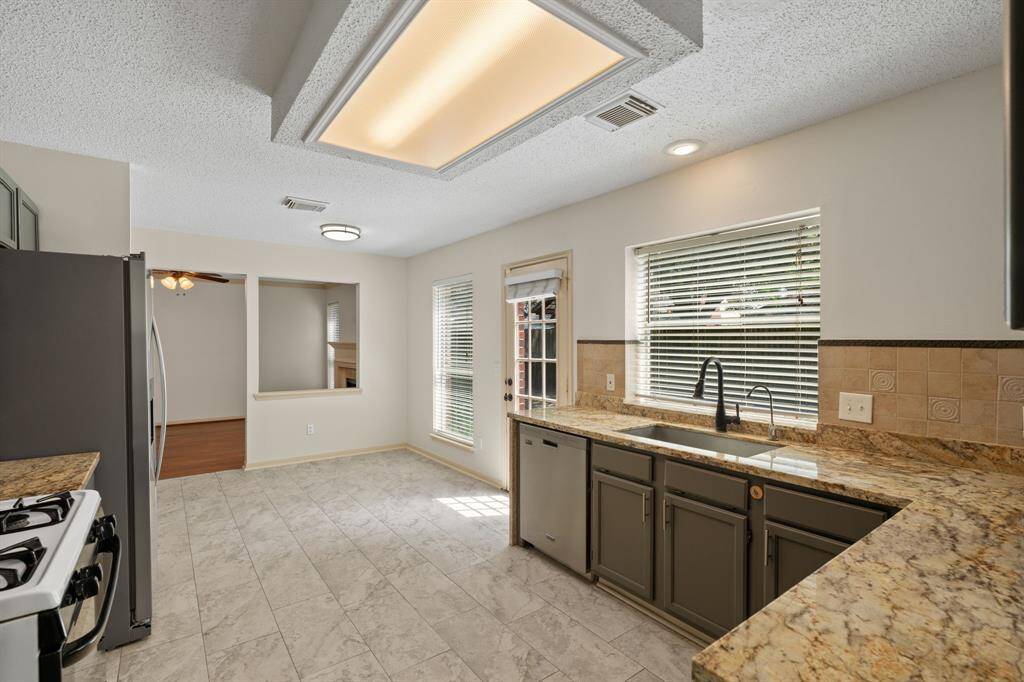 Step into this beautifully updated kitchen, boasting gleaming granite countertops and refreshed walls and cabinets. Generously sized, it offers space for a portable island, a built-in secretary desk, and a charming kitchenette nook.