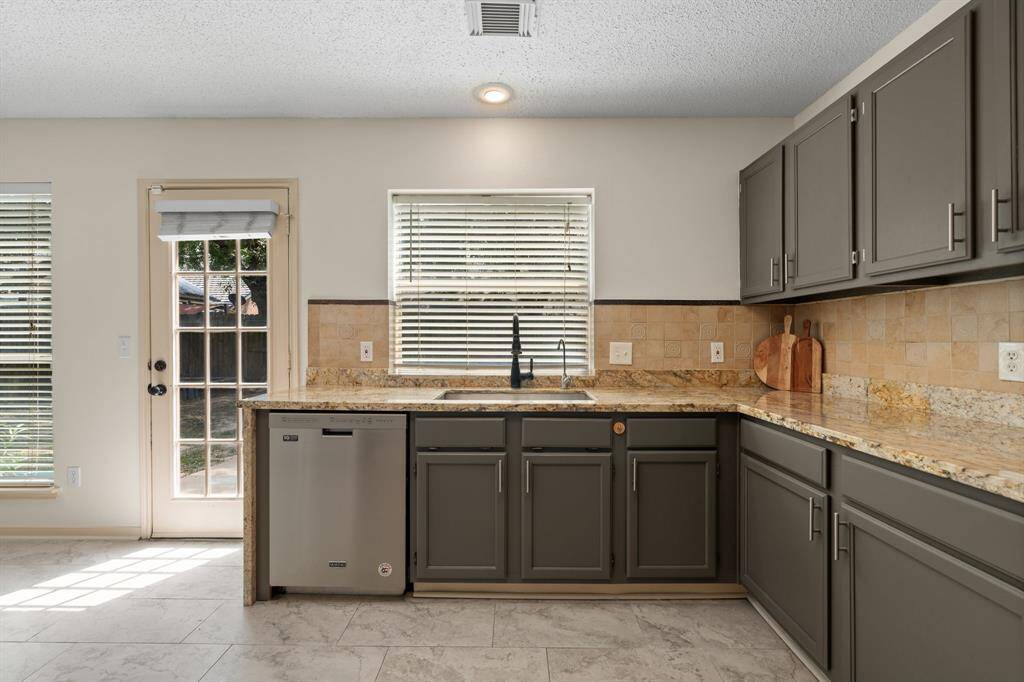 Step into this beautifully updated kitchen, boasting gleaming granite countertops and refreshed walls and cabinets. Generously sized, it offers space for a portable island, a built-in secretary desk, and a charming kitchenette nook.