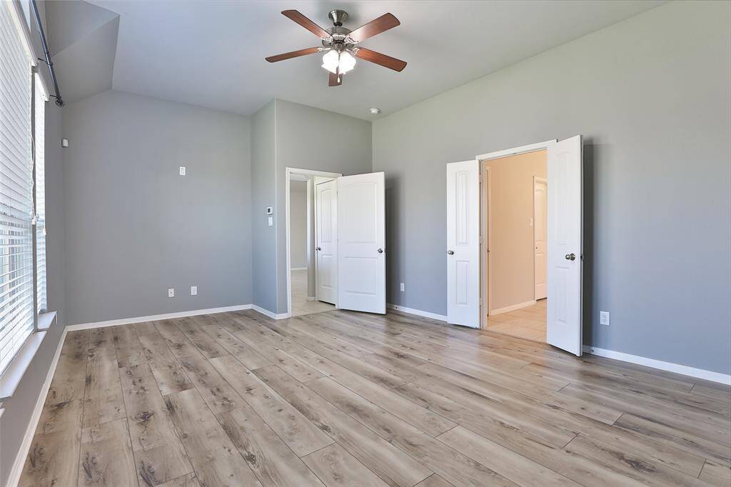 Large primary bedroom with updated flooring and lighting.