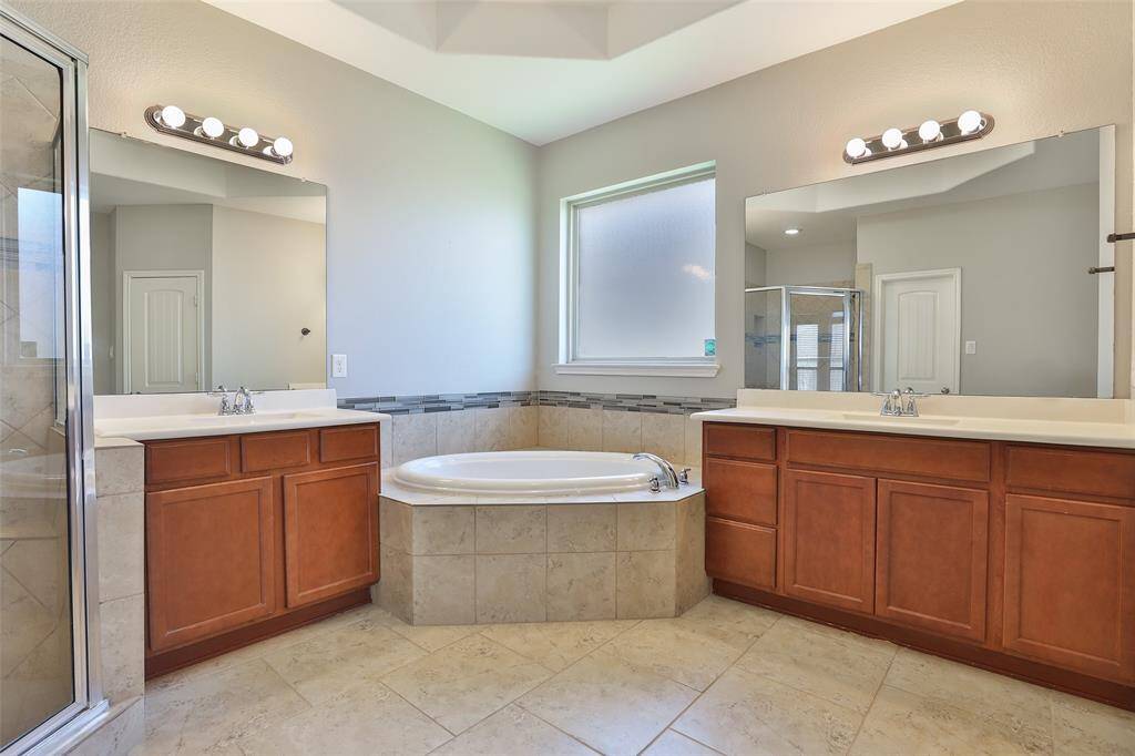 En suite bathroom offering soaker tub, separate shower, dual  sinks, private toilet area, walk in closet.