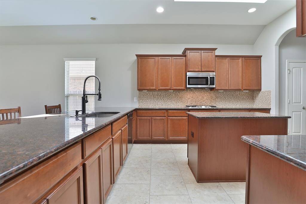 Open kitchen with plenty of natural light, ample counter/cabinet space, and large breakfast bar.