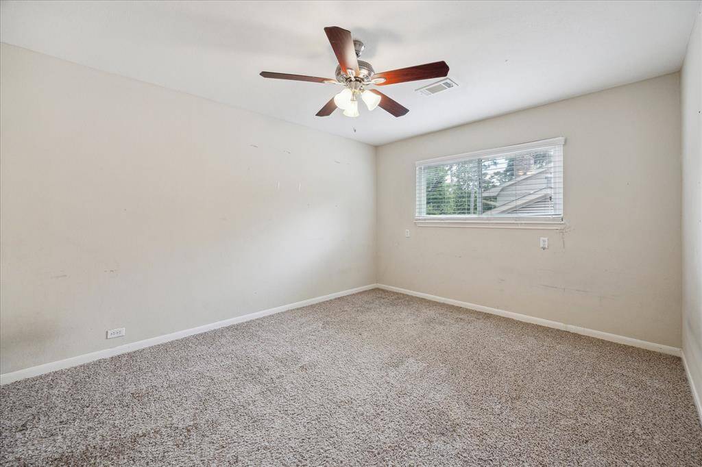 Secondary bedroom with neutral carpet, ample-sized closet, and lighted ceiling fan.