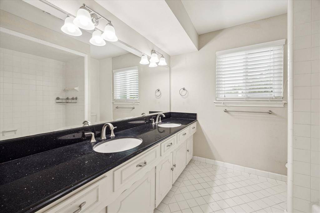 Upstairs full bath with an expansive dual-sink vanity, ample cabinet storage, and a tub/shower combo—serving the secondary bedrooms and gameroom with plenty of space.
