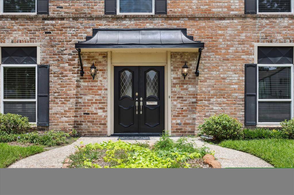 Charming walkway leads to the classic double-door entry with diamond-pane glass is framed by lantern-style sconces.