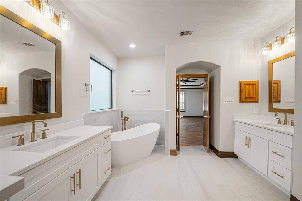 PRIMARY SUITE  Gorgeous RENOVATION completed! Quartz counter tops, stand alone tub, shower surround, lighting & plumbing fixtures. Large shower & dual closets complete this grand space.