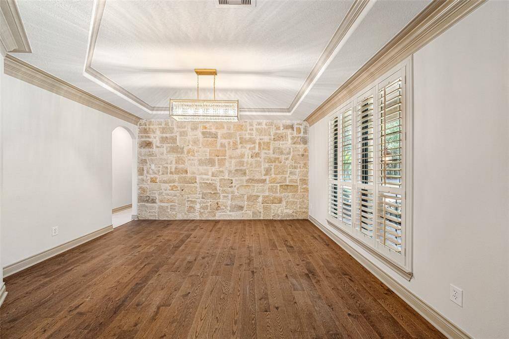 DINING ROOM New brushed gold rectangular LED light -ready to host the holidays with a fresh look. Grey stone in accent wall blends beautifully with the new tile floors visible at the Kitchen & Foyer.  LED lighting throughout the home.