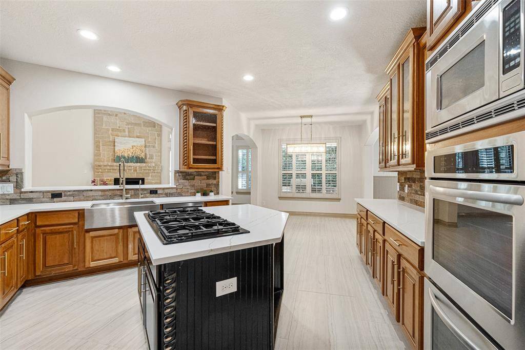 KITCHEN   New quartz counter tops & brushed gold plumbing fixtures & hardware plus tile floors. New Breakfast Room Lighting.