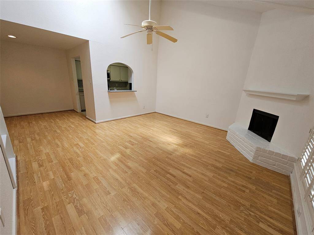 Another view of the living room with the fireplace and skylight that offers natural lighting