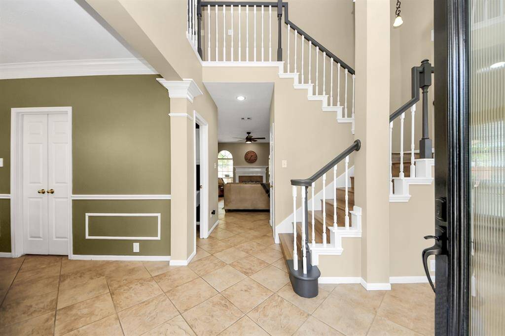 Two story entry with soaring ceilings and open staircase.