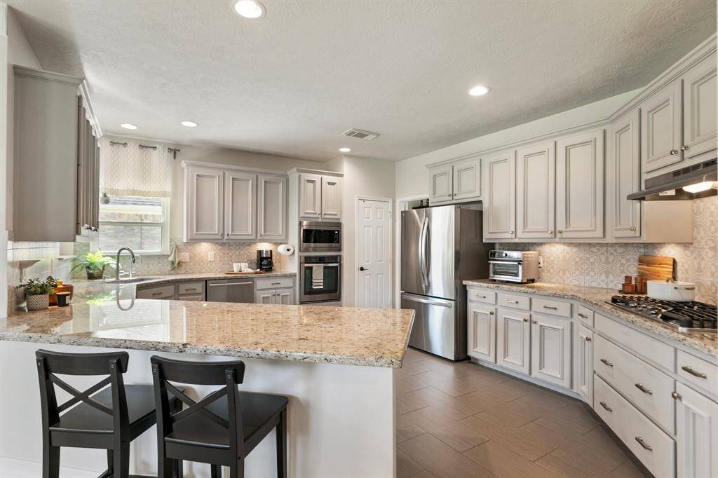 Gourmet kitchen, granite countertops, stainless steel appliances, 5 burner gas cooktop