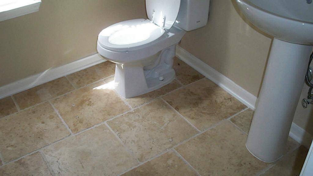 Half bath with new travertine floor.