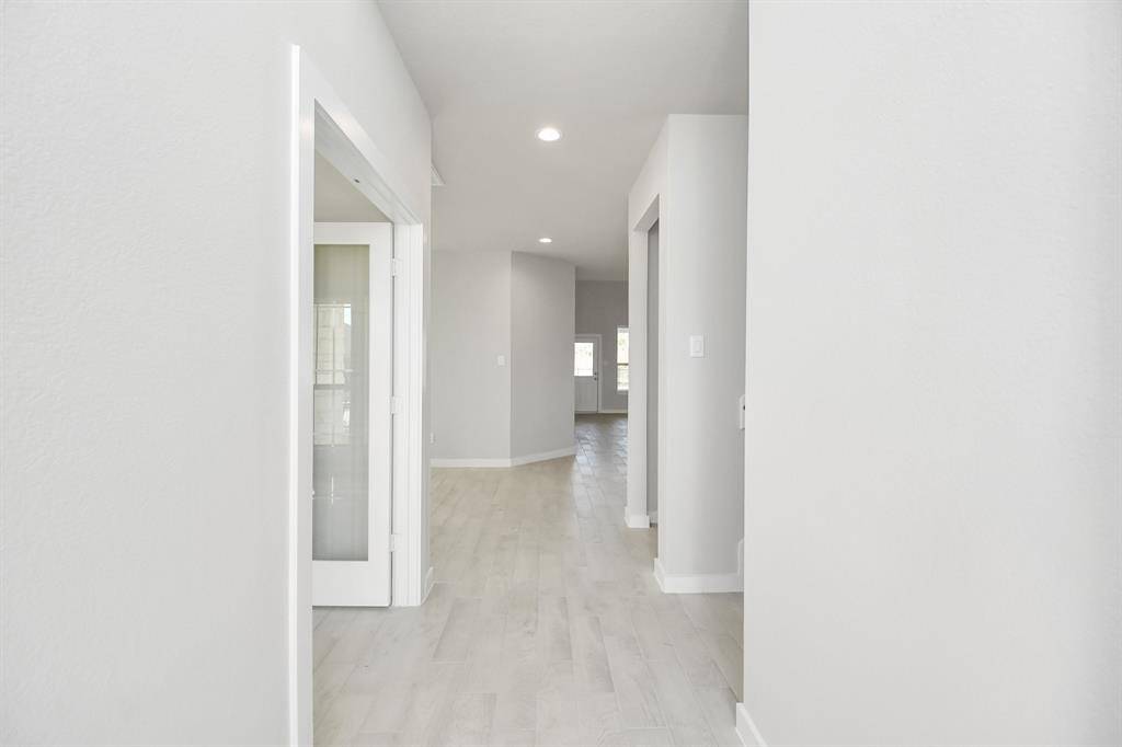 Experience luxury as you step into the threshold of this breathtaking home. The grand entrance beckons with its high ceilings, recessed lighting, and elegant wood-look tile flooring combined with oversized baseboards. Sample photo of completed home with similar floor plan. Actual colors and selections may vary.