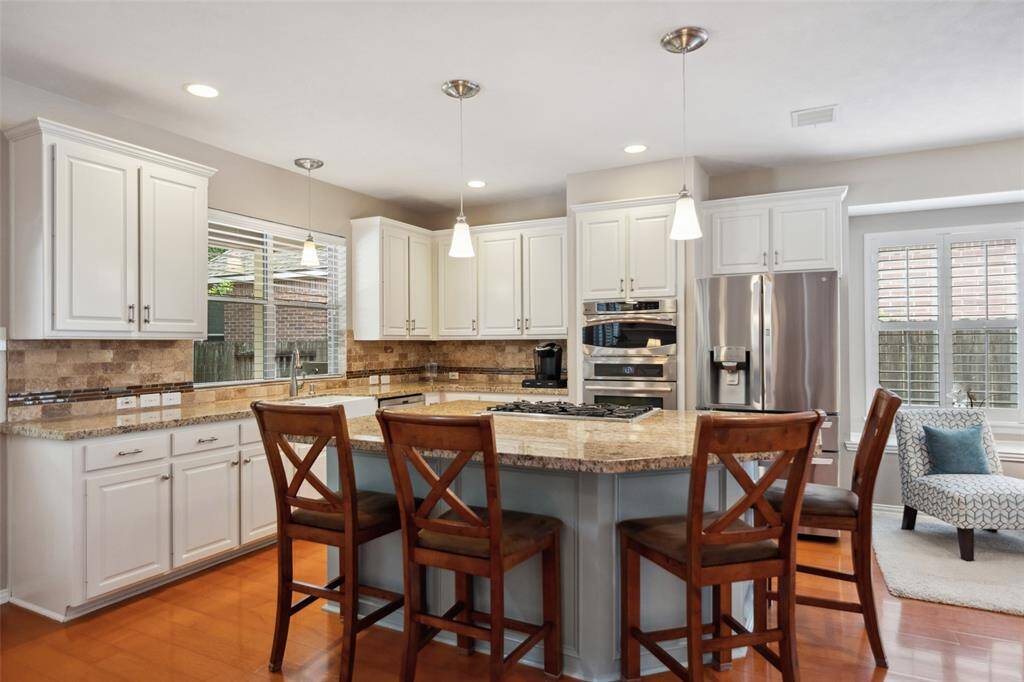 The large kitchen island has room for everyone. The large farmhouse sink overlooks the back yard.