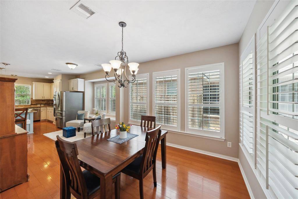 The formal dining room is bathed in large windows with shutters so you can enjoy the mature trees! Walk out to the large covered porch for indoor/outdoor entertaining.
