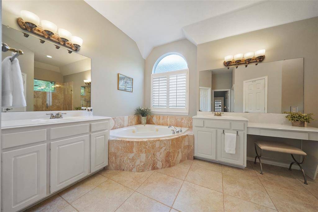 The primary bathroom is spacious with two separate vanities/sinks, a linen closet, commode room, and an huge walk in closet.