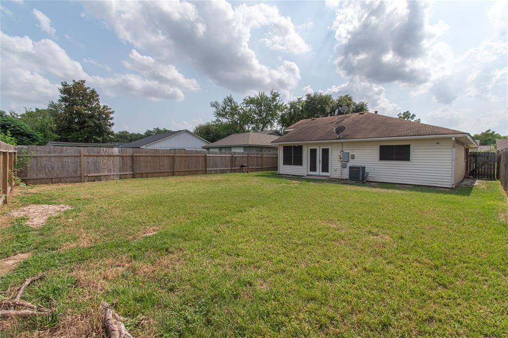 The house has a single-story design with a shingled roof and features a back patio area. It's ideal for outdoor activities and relaxation.