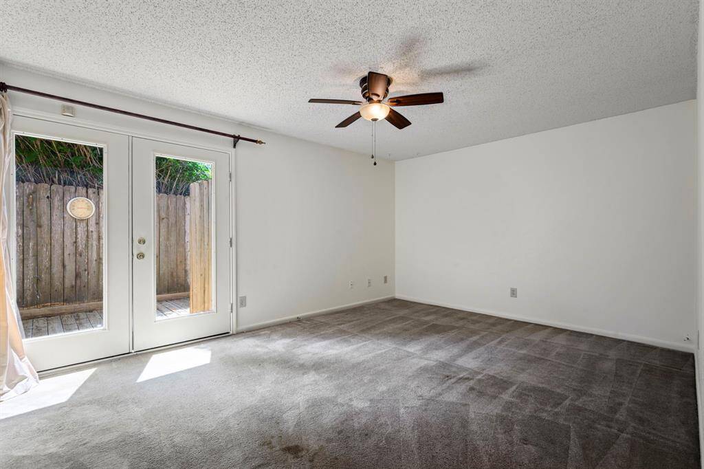 16x12 Primary Bedroom - Access the private patio through French doors and stay cool with a ceiling fan.