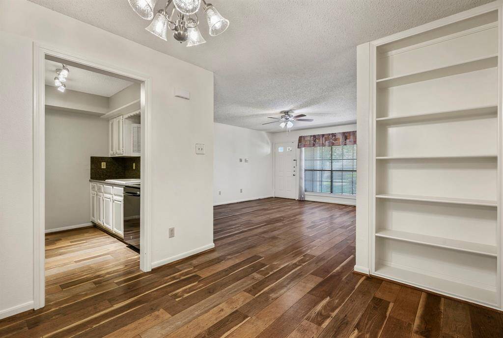 9x8 Dining Room - Standing in the dining area while looking left into the kitchen, right to the large built-in shelving and to the front door in the background.