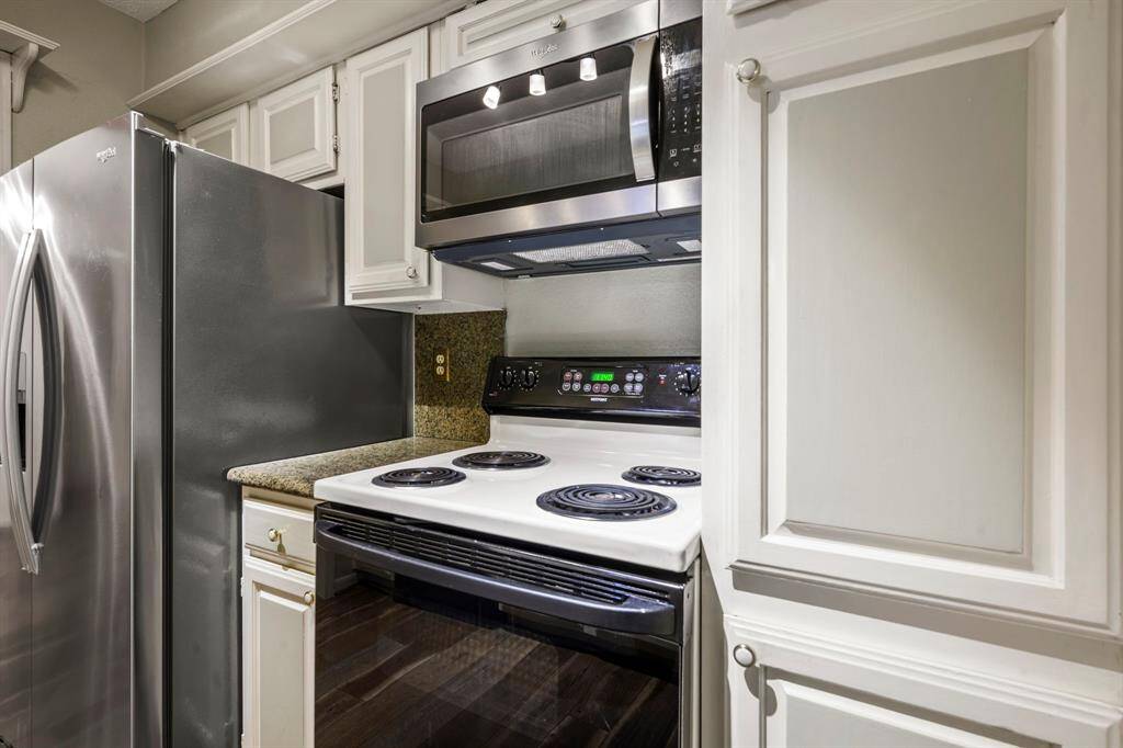 8x7 Kitchen - Opposite side of the kitchen shows electric range with microwave above and side by side refrigerator on the left.