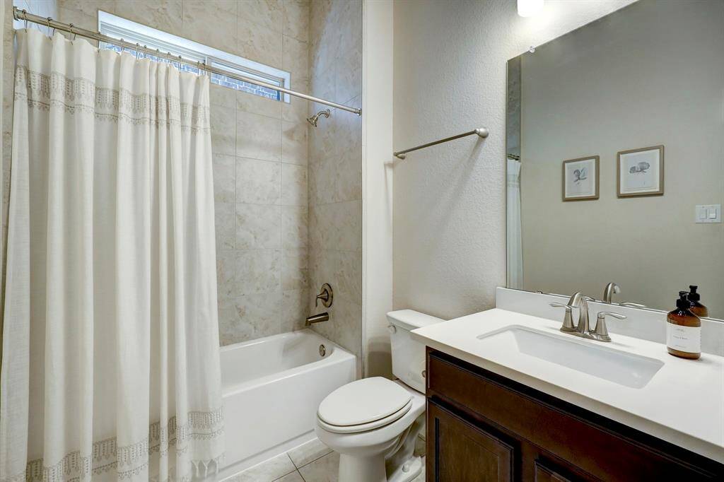 The guest bath conveniently located by the study, offers a beautiful vanity, and shower/bath combination.