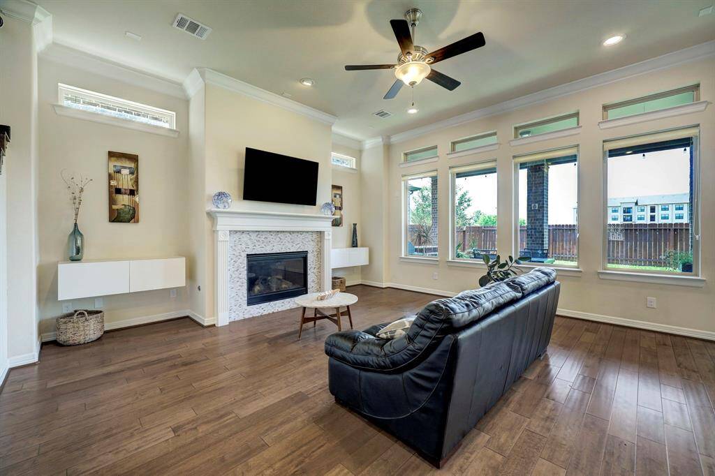Spacious open floor plan gives direct access to the inviting family room that boasts high-coffered ceilings, a neutral overall palette, hardwood floors, and window panels that offers a view of the lush backyard.