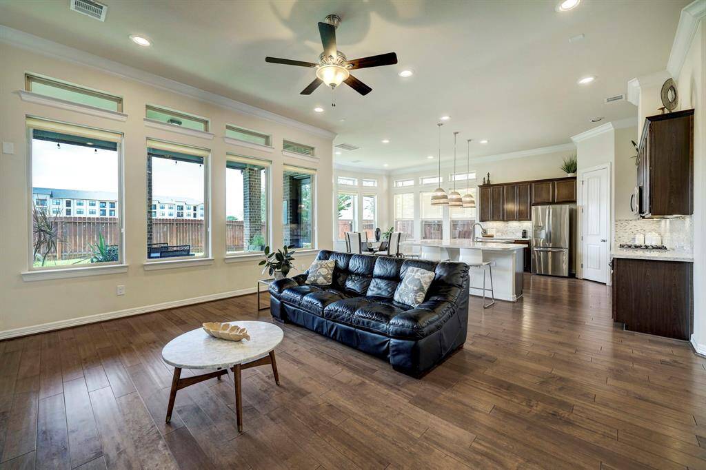 The seamless open floorplan allows for easy access from the family room to both the chef's kitchen and formal dining area. The well-placed window panels throughout the space flood it with an abundance of natural light, creating a bright and welcoming atmosphere.