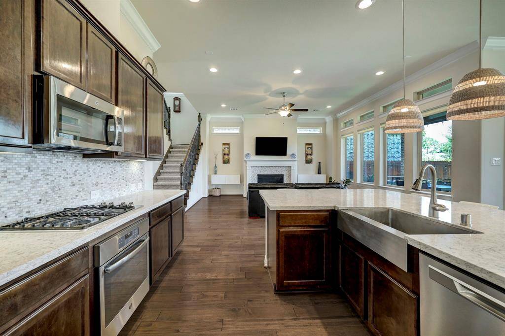 The beautiful dark wood-stained cabinetry in the kitchen perfectly complements the GE Cafe stainless steel appliances and overall ambiance of the home's open layout.