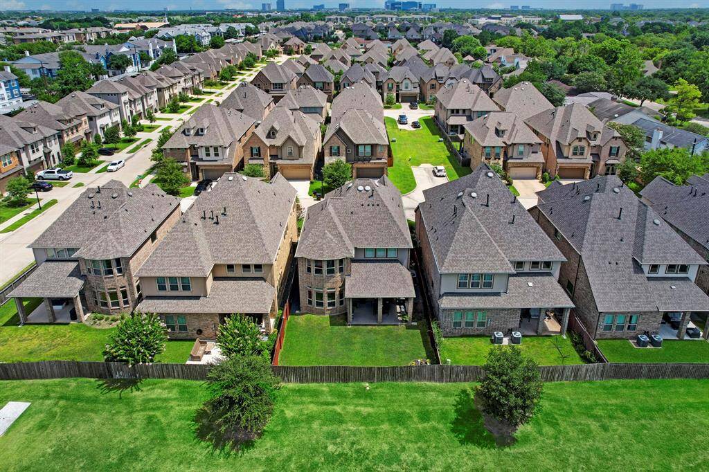 The captivating aerial view reveals the expansive backyard of the property, adorned with abundant greenery and offering a serene and picturesque setting.